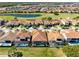 Gorgeous aerial view of homes featuring tile roofs, backyard pools, manicured lawns, and community lakes and golf course at 13319 Alderley Dr, Orlando, FL 32832