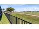 View of expansive backyard with golf course view and black metal fence surrounding the home at 13319 Alderley Dr, Orlando, FL 32832