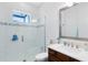 Bathroom featuring glass-enclosed shower with a window, vanity with mirror, and neutral tile at 13319 Alderley Dr, Orlando, FL 32832