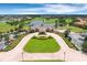 Stunning aerial view of the clubhouse entrance featuring manicured landscaping, a paved roundabout, and ample parking at 13319 Alderley Dr, Orlando, FL 32832