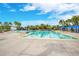 Large community pool area with a lap pool, beach entrance, lounge chairs, umbrellas, and a nearby building at 13864 Sachs Ave, Orlando, FL 32827