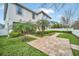 Landscaped backyard showcases a brick pathway, green lawn, and lush plantings at 14150 Aldford Dr, Winter Garden, FL 34787