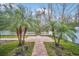 Well-maintained backyard area featuring lush landscaping, brick pathway, and white picket fence at 14150 Aldford Dr, Winter Garden, FL 34787