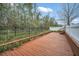 An expansive wooden backyard deck featuring black metal fencing, lush foliage, and outdoor appeal at 14150 Aldford Dr, Winter Garden, FL 34787