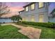 Backyard at dusk showcasing brick pathway, lawn and the home's exterior at 14150 Aldford Dr, Winter Garden, FL 34787