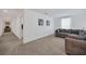 Bonus room featuring plush carpeting, a comfortable gray sofa, and natural light at 14150 Aldford Dr, Winter Garden, FL 34787