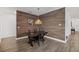 Dining area featuring accent wall, stylish light fixture, wood-look floors, and adjacent stairway at 14150 Aldford Dr, Winter Garden, FL 34787