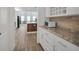 Well-lit kitchen with granite countertops, white cabinetry, and stainless steel microwave oven at 14150 Aldford Dr, Winter Garden, FL 34787