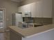 The kitchen features white appliances and cabinets and double doors to the outside at 145 Reserve Cir # 113, Oviedo, FL 32765