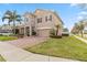 Two-story home showcasing a blend of stone and stucco, complemented by a brick driveway and manicured lawn at 1700 Leatherback Ln, St Cloud, FL 34771