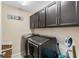 Efficient laundry room with modern appliances and storage cabinets at 1700 Leatherback Ln, St Cloud, FL 34771