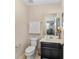 A half bath featuring modern fixtures, a vanity, and a commode at 1700 Leatherback Ln, St Cloud, FL 34771