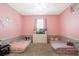 Pink bedroom features two twin beds, a ceiling fan, and a dresser with television at 1775 Copinger Ter, Kissimmee, FL 34744