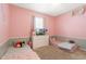 Pink bedroom features two twin beds, a ceiling fan, and a dresser with television at 1775 Copinger Ter, Kissimmee, FL 34744