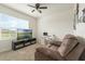 Comfortable living room features a ceiling fan, a window with natural light, and a television at 1775 Copinger Ter, Kissimmee, FL 34744