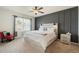 Serene main bedroom with a panel accent wall, ceiling fan, neutral carpet, and ample natural light at 1775 Copinger Ter, Kissimmee, FL 34744