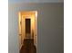 Hallway view into a bathroom, featuring neutral paint colors, wood-look flooring, and modern lighting at 1909 Caralee Blvd # 4, Orlando, FL 32822