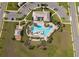 Overhead view of a neighborhood pool featuring multiple seating areas, a splash pad, and a park at 1920 Perch Hammock Loop, Groveland, FL 34736