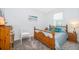 Inviting bedroom with light blue walls, a wooden bed frame, and natural light from the window at 1920 Perch Hammock Loop, Groveland, FL 34736