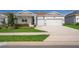 Exterior shot of a well-maintained home featuring a two-car garage, a stone accent base, and a driveway at 1920 Perch Hammock Loop, Groveland, FL 34736