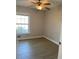 This is a brightly lit bedroom that features a ceiling fan and light fixture with hardwood floors and a window at 2025 Dixie Belle Dr # 2025 B, Orlando, FL 32812