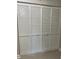 A closet featuring four white folding doors made of wood, with slats and round knobs, on a light wood floor at 2025 Dixie Belle Dr # 2025 B, Orlando, FL 32812