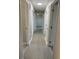 A view of the hallway, with many white doors, and light-colored floors, leading to multiple rooms at 2025 Dixie Belle Dr # 2025 B, Orlando, FL 32812