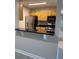 A kitchen pass through shows wood cabinets, black countertops and stainless steel appliances at 2025 Dixie Belle Dr # 2025 B, Orlando, FL 32812