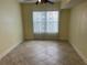 Bright bedroom featuring a ceiling fan, tile flooring, and a large window at 204 E South St # 5058, Orlando, FL 32801