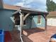 A covered outdoor patio with a wooden frame, brick flooring, and blue siding at 214 Great Yarmouth Ct, Kissimmee, FL 34758