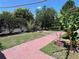 Picturesque backyard with brick pathway, banana tree, and mature trees at 214 Great Yarmouth Ct, Kissimmee, FL 34758