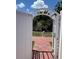 White archway entrance to a lush green backyard with brick pathway at 214 Great Yarmouth Ct, Kissimmee, FL 34758