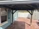 Covered patio area featuring a wooden frame, brick flooring, and a view of a white fence and storage shed at 214 Great Yarmouth Ct, Kissimmee, FL 34758