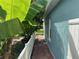 Side yard view of a house with a brick walkway lined by a white fence and lush greenery at 214 Great Yarmouth Ct, Kissimmee, FL 34758