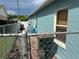 A view of a house exterior with a metal fence, a brick walkway, and green garbage bins at 214 Great Yarmouth Ct, Kissimmee, FL 34758