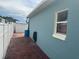 View of a house exterior featuring a blue wall, a white fence, and a brick walkway at 214 Great Yarmouth Ct, Kissimmee, FL 34758