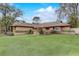 Landscaped front yard with a charming home featuring a brown roof and wood siding at 2227 Palm Vista Dr, Apopka, FL 32712