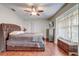 Primary bedroom featuring a large window, wood floors, a fan, and a dresser with a wall mounted TV at 2227 Palm Vista Dr, Apopka, FL 32712