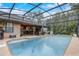 A wide view of the screened-in pool area with chairs, and exterior entertaining area at 2227 Palm Vista Dr, Apopka, FL 32712