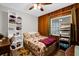 A well-decorated bedroom with wooden walls, a quilted bed and built in storage shelves at 2251 Chippewa Trl, Maitland, FL 32751