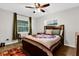 Bright bedroom featuring a large window, unique patterned bedding, and wooden flooring at 2251 Chippewa Trl, Maitland, FL 32751