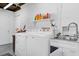 Well-lit laundry area with white brick walls, washer, dryer, and utility sink at 2251 Chippewa Trl, Maitland, FL 32751