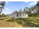 A view of the back of the house in a backyard with grass and some trees at 2483 Sw 163Rd Pl, Ocala, FL 34473