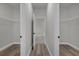 Hallway with wood-look floors features a linen closet and access to rooms at 2483 Sw 163Rd Pl, Ocala, FL 34473