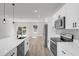 Well-lit modern kitchen showcasing stainless steel appliances, white cabinets, a breakfast bar, and wood-look flooring at 2483 Sw 163Rd Pl, Ocala, FL 34473