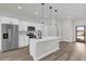 Bright kitchen with stainless steel appliances, white cabinetry, an island with pendant lighting, and wood-look flooring at 2483 Sw 163Rd Pl, Ocala, FL 34473