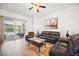 Bright living room with leather seating, wood floors, and a sliding door to the outdoor patio at 2614 Brookshire Ct, Kissimmee, FL 34746