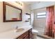 Cozy bathroom with a tiled shower/tub, single vanity with dark wood cabinets, and dark wood-framed mirror at 27127 Stoney Brook Dr, Leesburg, FL 34748