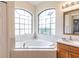 This bright bathroom has a large soaking tub beneath beautiful windows, and a vanity at 27127 Stoney Brook Dr, Leesburg, FL 34748