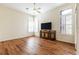 Bright bedroom with hardwood floors, a ceiling fan, a TV, and bright natural light from large windows at 27127 Stoney Brook Dr, Leesburg, FL 34748